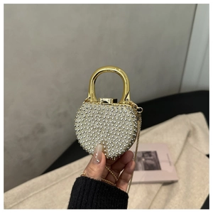Detail of heart-shaped evening bag featuring sparkling rhinestones and golden top handle