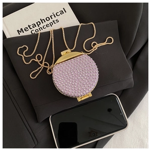 Dettaglio della mini borsa di paillettes viola con borchie e sottile catena d'oro