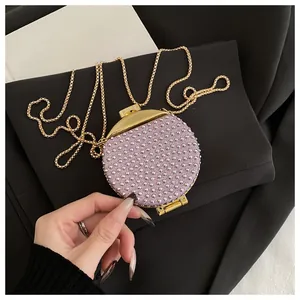 Dettaglio della mini borsa da sera rotonda con strass viola e catena dorata sottile