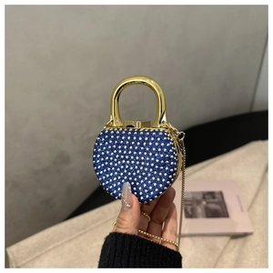 Macro shot of royal blue acrylic evening bag with silver rhinestones and gold handle