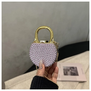 Detail of pink glitter heart bag with silver studs, gold handle and metal chain strap