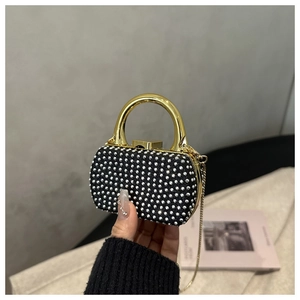 Detail of a luxury evening box bag with silver rhinestones and a gold metal handle