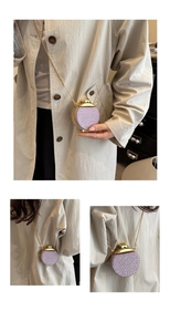 Dettaglio borsa da sera con perline viola con montatura dorata e tracolla su cappotto