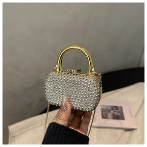 Detail of luxury rhinestone evening clutch with gold chain and handle held by hand