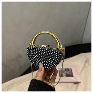Close-up of sparkling rhinestone mini evening bag with round gold handle and chain strap