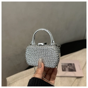 Detail of silver rhinestone evening bag with metal handle and chain strap