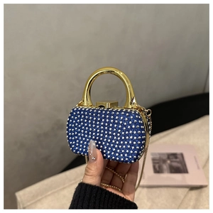 Detail of mini acrylic evening bag featuring silver rhinestones and gold handle
