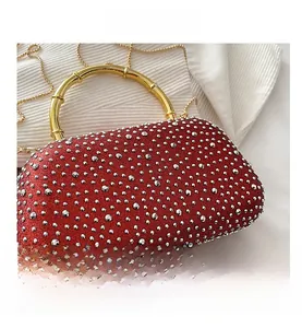 Close-up of red rhinestone evening bag with luxury golden bamboo handle and chain