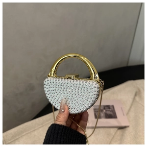 Close-up of semi-circle evening bag with rhinestones and golden metal top handle