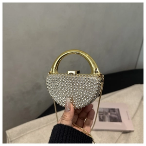 Detail of rhinestone dinner bag with gold metal frame and rigid circular handle