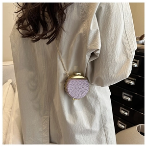 Dettaglio della mini borsa da sera rotonda viola con perline e tracolla dorata