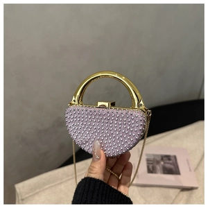 Detail of pink rhinestone evening bag with gold handle and chain for party