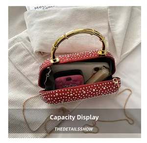 Top view of red rhinestone evening bag interior with gold bamboo handle and chain