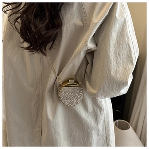 Vista dettagliata della mini borsa da sera con strass e catena dorata su un modello