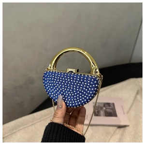 Detail of navy blue rhinestone evening bag with elegant gold metal handle and chain