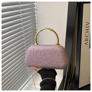 Pink rhinestone evening bag featuring a gold bamboo handle and metal chain strap details