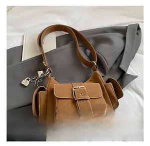 Detail of brown vintage tote bag with silver heart lock and bow charm on grey blazer