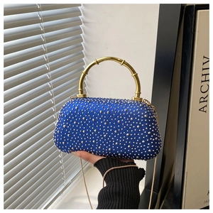 Detail of glitter evening bag with silver studs and golden bamboo-style handle
