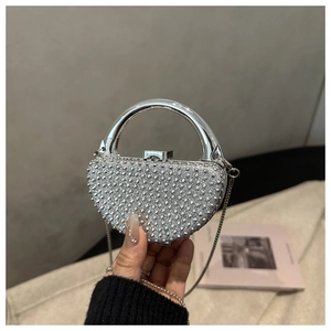 Detail of silver rhinestone evening bag with round metal handle and delicate chain