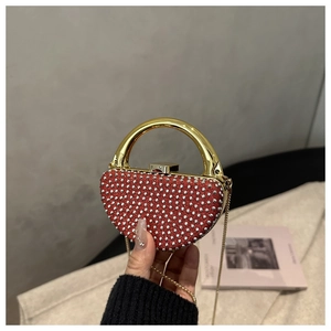 Detailed macro view of heart-shaped evening bag with red base and silver rhinestones