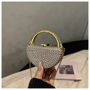 Detailed view of shimmering rhinestone evening bag with elegant golden circular metal handle