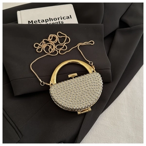 Detail of rhinestone evening bag with gold circular handle on a black blazer