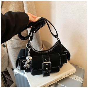Detail of black matte shoulder bag with white stitching and metallic heart charms