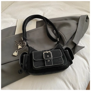 Detail of black suede shoulder bag featuring contrast stitching and metal heart charms