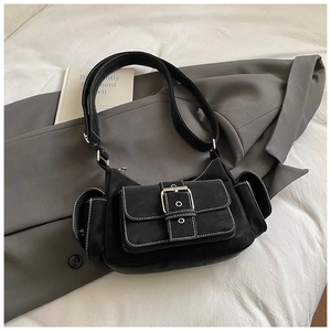 Detail of black Y2K faux suede shoulder bag with white contrast stitching and silver buckle