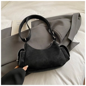 Detail of crescent shoulder bag with white contrast stitching and side pocket on blazer
