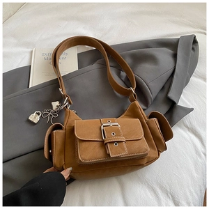 Detail of caramel vintage leather tote with metal buckle and silver lock charm