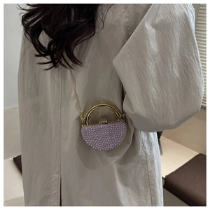 Detail of purple rhinestone mini evening bag with gold handle and chain strap on model