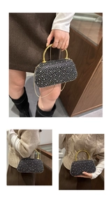 Close-up of black evening clutch featuring sparkling rhinestones and a gold bamboo handle