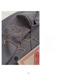 Detail of creative playing card clutch bag with red and silver rhinestones and gold chain