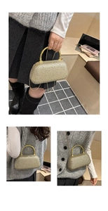 Detail of evening clutch with pearl rhinestones and golden bamboo handle stylish design
