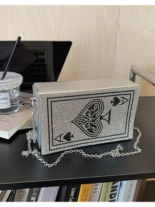 Detail of silver evening clutch featuring a sparkling rhinestone Ace of Spades poker pattern