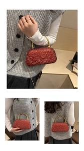 Detail of red rhinestone clutch bag with gold bamboo handle and chain strap for evening wear