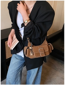 Detail of vintage brown leather shoulder bag with silver lock charm and strap buckle