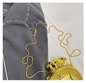 Close-up of golden lucky bag crossbody bag featuring floral relief and slim chain strap