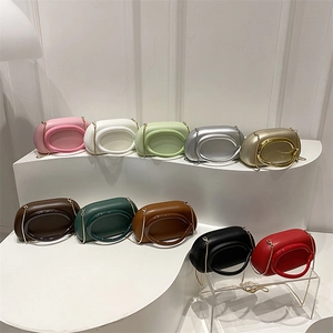 Minimalist geometric clutch bag with oval cutout handle and gold chain strap in multi-colors