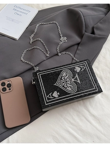 Macro detail of luxury spade A rhinestone evening clutch with fine silver metal chain strap