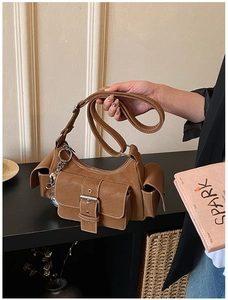 Detail of vintage brown crossbody bag featuring multiple pockets and silver buckles