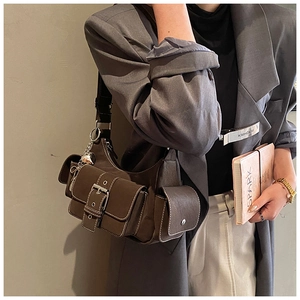 Detail of dark brown vintage shoulder bag with multiple pockets and heart charm