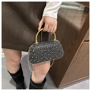 Dettaglio borsa da sera nera con strass argento e manico in metallo a bambù dorato