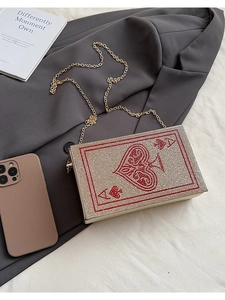 Detail of playing card clutch with sparkling rhinestones and golden chain strap