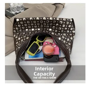 Detail view of the brown studded handbag showing its large internal storage capacity