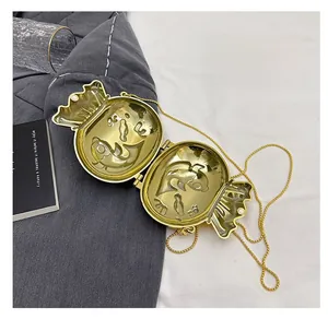 Detail view of the sleek gold candy-shaped evening bag interior with metal chain