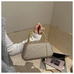 Dettaglio della borsa da sera in acrilico champagne con strass e manico in metallo a bambù