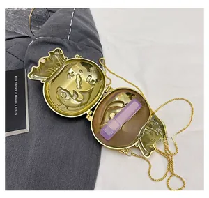 Detailed close-up of golden lucky bag charm bag with embossed fish patterns and chain