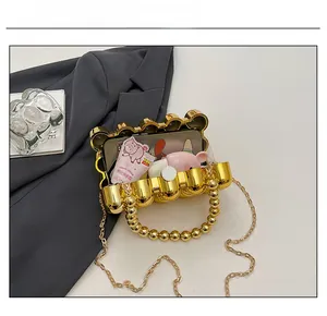 Detailansicht der goldenen Jelly-Tasche mit Innenkapazität und eleganter Metallkette